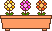 3 verschiedenfarbige Blumen in einem Blumenkasten