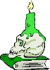 Totenkopf von der Seite mit brennender grüner Kerze auf einem grünen Buch